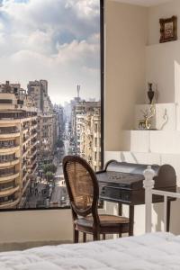 a bedroom with a desk and a view of a city at Sunny Vintage Haven "Dual balconies, Panorama" in Cairo