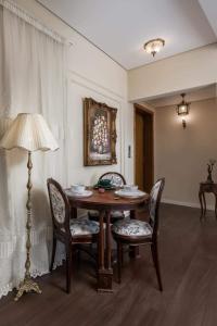 a dining room with a table and chairs and a lamp at Sunny Vintage Haven "Dual balconies, Panorama" in Cairo