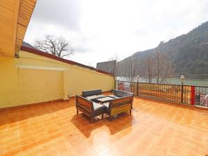 a balcony with a piano on a wooden floor at Hotel Flatties Mall Road Lake View Nainital - Excellent Service Recommended in Nainital