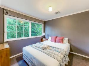 1 dormitorio con cama y ventana en Pride Leisure Tudor House en Park Orchards