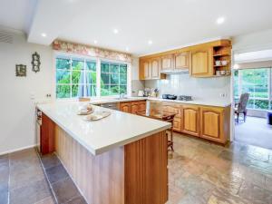 cocina con armarios de madera y encimera blanca en Pride Leisure Tudor House en Park Orchards