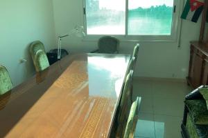 a dining room table with chairs and a table and a window at Convenient Spacious apartment in Amman