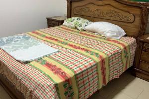 ein Bett mit einer Decke und Kissen darauf in der Unterkunft Convenient Spacious apartment in Amman