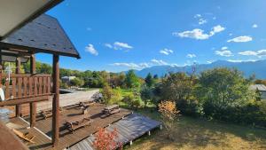 una terraza de madera con bancos y vistas a las montañas en Place yatsugatake Lodge&cottage, en Hokuto