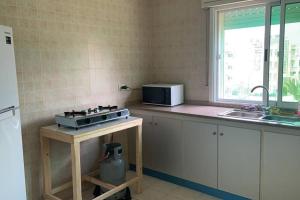 a kitchen with a stove and a microwave on a counter at Convenient Spacious apartment in Amman