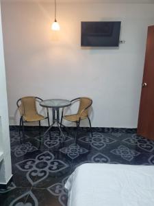a room with a table and two chairs and a bed at Confort 13-47 in Cali