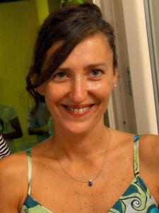 a woman is smiling while wearing a necklace at B&B Il Grifone in Pistoia