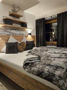 ラムサウ・イム・ツィラータールにあるLuxus Apartment Nina mit Zirbenhütteのベッドルーム1室(大型ベッド1台、白黒の毛布、枕付)