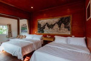 1 dormitorio con 2 camas y una pintura de un caballo en A HOUSE, en Koh Larn