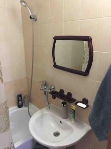 W łazience znajduje się umywalka oraz prysznic z lustrem. w obiekcie Дизайнерская квартира с барной стойкой по Бозтаева w mieście Semej
