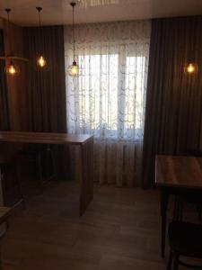 una sala de estar con una gran ventana con cortinas en Дизайнерская квартира с барной стойкой по Бозтаева, en Semey