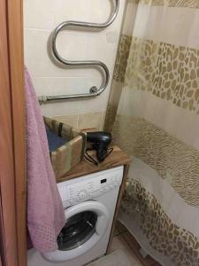 a washing machine in a bathroom with a towel at Дизайнерская квартира с барной стойкой по Бозтаева in Semey