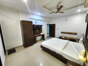 1 dormitorio con 1 cama y TV de pantalla plana en Hotel Amidhara, en Dwarka