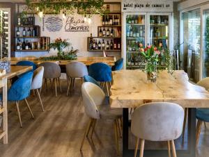 un restaurante con mesas de madera y sillas azules en Playa de Camariñas, en Camariñas