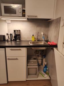 una pequeña cocina con fregadero y microondas en Kauppakatu 57 - 8, en Varkaus