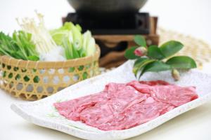 a plate of meat next to a basket of vegetables at Hotel Binario Saga Arashiyama in Kyoto