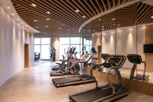 ein Fitnessstudio mit einer Reihe von Laufbändern und Crosstrainern in der Unterkunft Holiday Inn Hangzhou Gongshu, an IHG Hotel in Hangzhou