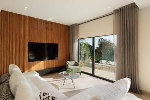 a living room with a couch and a tv at Nisos Villa Emerald in Kornáta