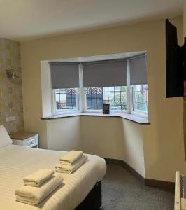 ein Schlafzimmer mit einem Bett und einem Fenster mit Handtüchern darauf in der Unterkunft The Bournbrook Inn in Birmingham