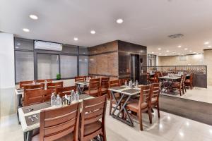 a restaurant with tables and chairs in a room at The Auberge Boutique Hotel - Manyata Tech Park in Bangalore