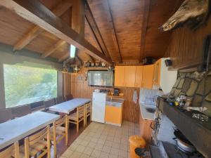 una cocina con mesas y sillas en una cabaña en Вила Беевски, en Gela
