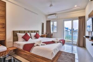 a bedroom with a large bed and a large window at The Auberge Boutique Hotel - Manyata Tech Park in Bangalore