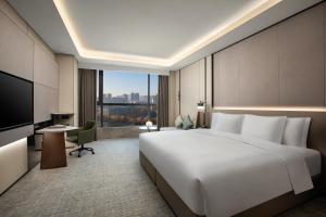 a hotel room with a large bed and a television at Crowne Plaza Zhengzhou High Tech Zone, an IHG Hotel in Zhengzhou