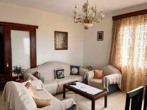 soggiorno con divani e lampadario pendente di Eliza Apartment Atheras a Athéras