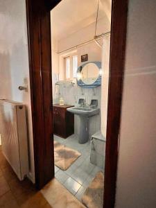 bagno con lavandino, servizi igienici e specchio di Eliza Apartment Atheras a Athéras