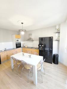 a kitchen with a white table and chairs in a room at La suite Carolo in Charleville-Mézières +3 photos