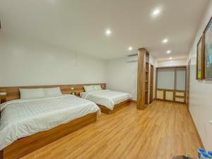 Duas camas num quarto com pisos em madeira em Bình Yên Villa - Mộc Châu em Mộc Châu