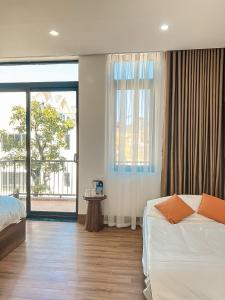 um quarto com uma cama e uma grande janela em Bình Yên Villa - Mộc Châu em Mộc Châu