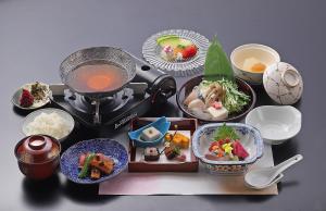 une table recouverte de assiettes et de bols de nourriture dans l'établissement Ryokan Sanoya, à Kyoto