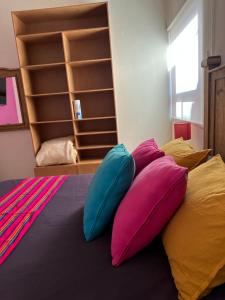 a pile of pillows sitting on top of a bed at Recámara con terraza y Firepit privados in Santiago