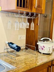 a kitchen counter with wine glasses and a sink at Casa Winnie in Kelaniya