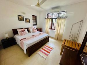 a bedroom with a large bed and a window at Casa Winnie in Kelaniya