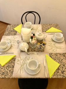 une table avec des serviettes et des plaques jaunes, dans l'établissement Hotel Arcadia, à Macerata
