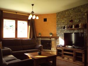 Casa Rural O Fraginal في Guasillo: غرفة معيشة بها أريكة وتلفزيون