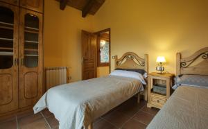 ein Schlafzimmer mit 2 Betten und einem Tisch mit einer Lampe in der Unterkunft Casa Rural O Fraginal in Guasillo