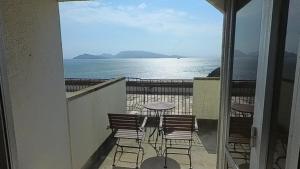 balcone con sedie, tavolo e vista sull'oceano di HOTEL GREEN PLAZA SHODOSHIMA - Vacation STAY 81149v a Ikisue