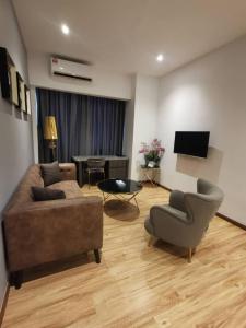 a living room with a couch and chairs and a television at Sentral View Hotel Bintulu in Bintulu