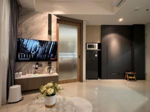 a living room with a tv on the wall at Apartment Nuvasa Bay Nongsa, Kalani 1BR 8th, Sea & Golf View, Batam in Nongsa
