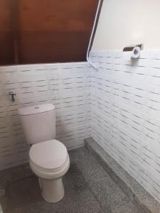 ein Badezimmer mit einem weißen WC und einer Rolle Toilettenpapier in der Unterkunft Carasti Bungalows in Masbagik