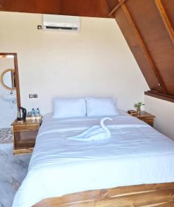 ein Schlafzimmer mit einem großen Bett mit blauer Bettwäsche in der Unterkunft Carasti Bungalows in Masbagik