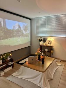 un salon avec une table et un grand écran dans l'établissement Hongdae station 7min, Designer house, à Séoul