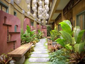 a walkway in a building with a bench and plants at The Signature Hoi An in Hoi An