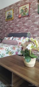 a bedroom with a bed and a table with a potted plant at SofiaSuite16, Plaza Azalea, Shah Alam in Shah Alam