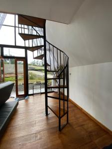 spiralne schody w pokoju z drewnianą podłogą w obiekcie Zaa Villa w mieście Diyeng