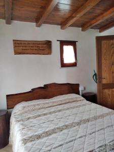 Schlafzimmer mit einem großen Bett mit einem Kopfteil aus Holz in der Unterkunft La Casetta della valle di Civita in Bagnoregio