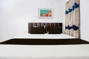a bedroom with a bed with a black and white bedspread at OYO Premier Jim Corbett Home Stay in Rāmnagar